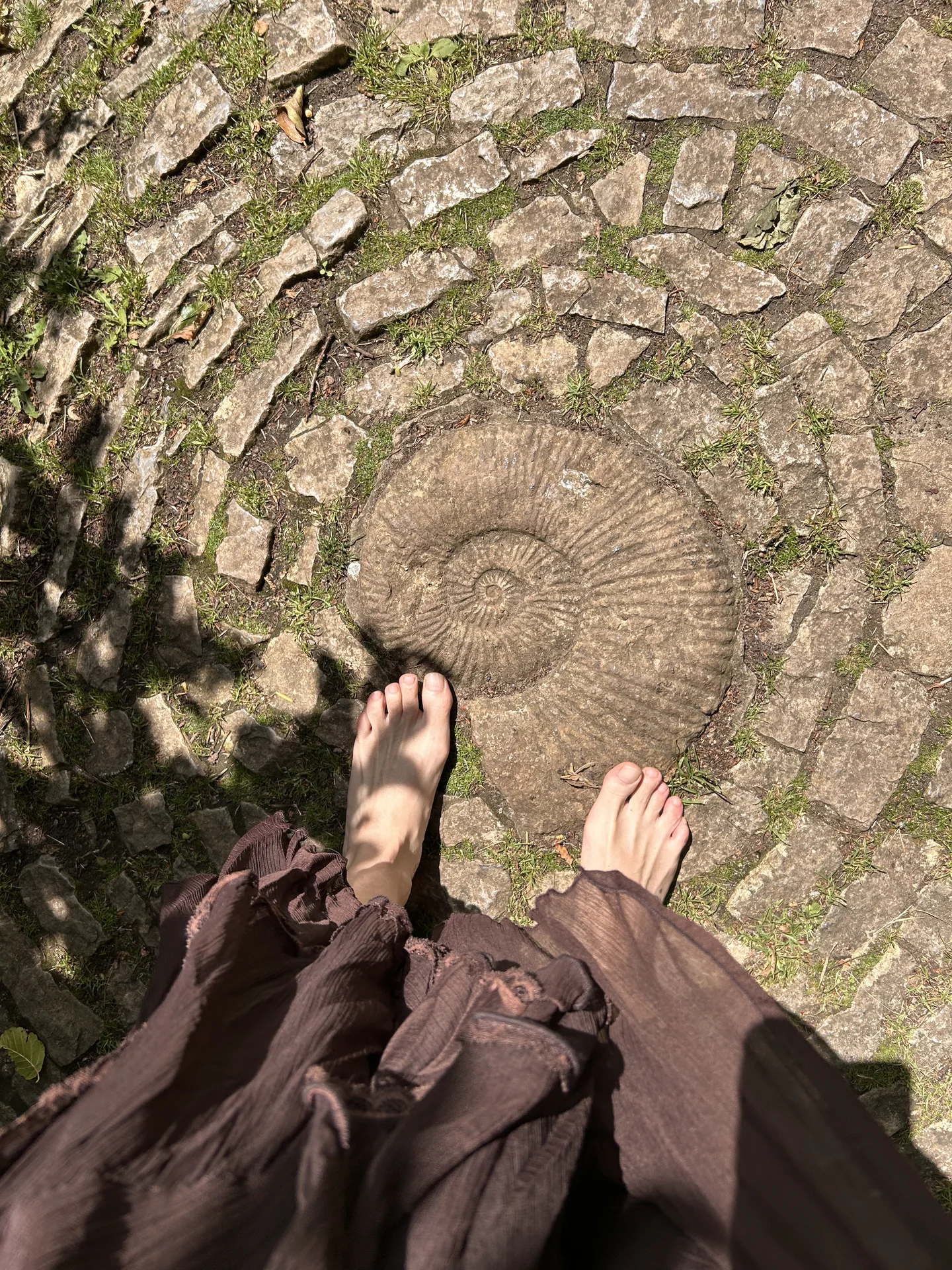 Pies descalzos sobre el laberinto de piedra en Glastonbury