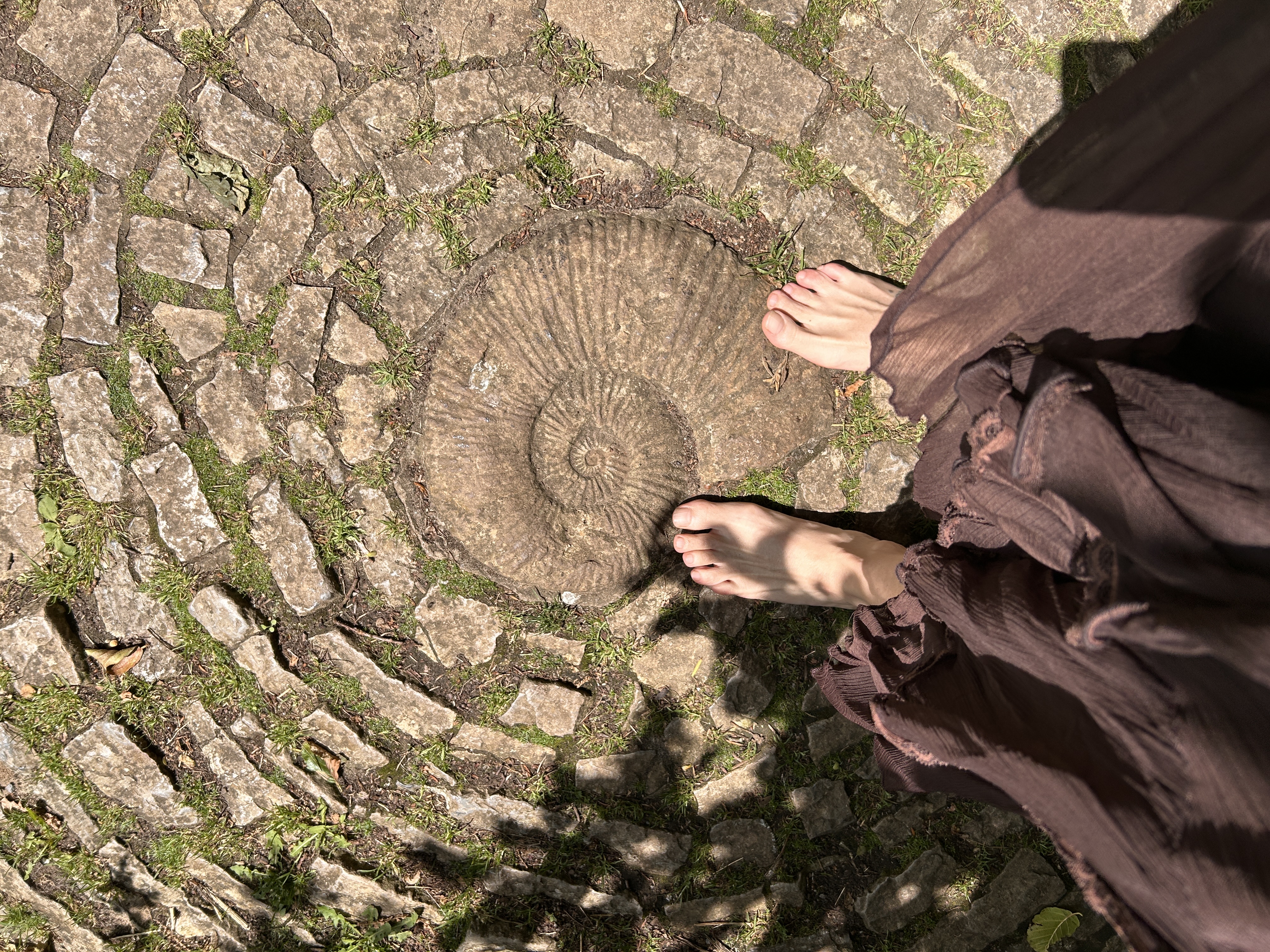 Pies descalzos sobre el laberinto de piedra en Glastonbury