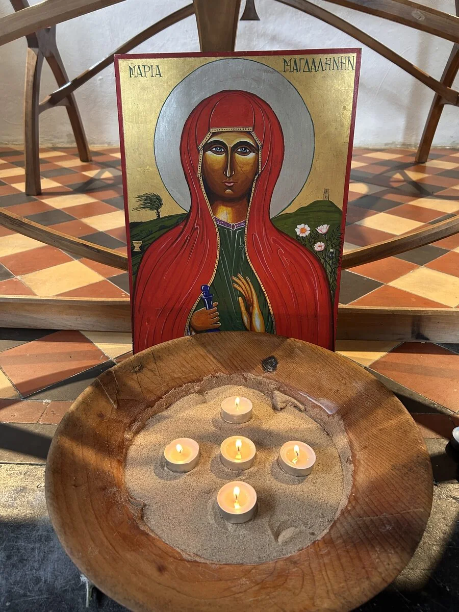 Velas encendidas junto a un icono de María Magdalena