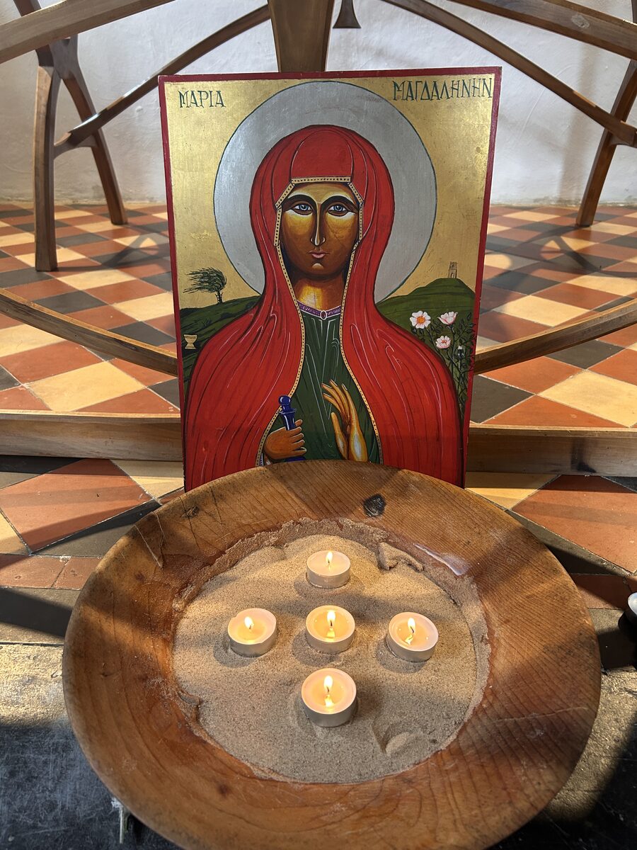 Velas encendidas junto a un icono de María Magdalena