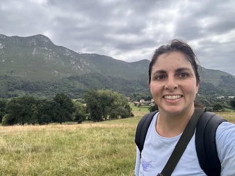 Alejandra con mochila ante un paisaje de montañas